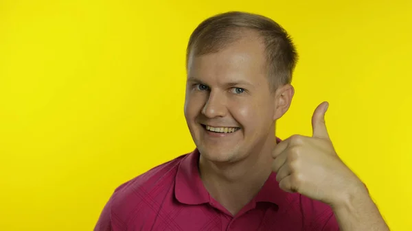 Portrét bělocha pózujícího v tričku. Usmívající se pohledný chlapík ukazuje palec nahoru. Emoce lidí — Stock fotografie