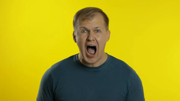 Portrait of young caucasian man posing in green t-shirt. Amazed handsome guy shocked, surprised — Stock Photo, Image