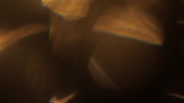 Işık sızıntısı 4K görüntüsü. Lens parlaklığı bokeh örtüleri, yanan alev arka planı. Flaş ışınları etkisi