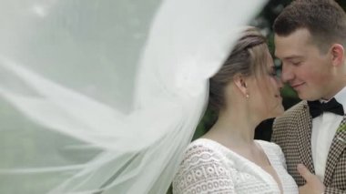 Yeni evliler. Gelin ile beyaz damat parkta yürüyor, sarılıyor, sarılıyor. Düğün çifti