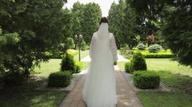 Gelin, genç bir kadın yeşil yaz parkında yürüyor. Dikiz aynası. Sevgili kocasına gider.