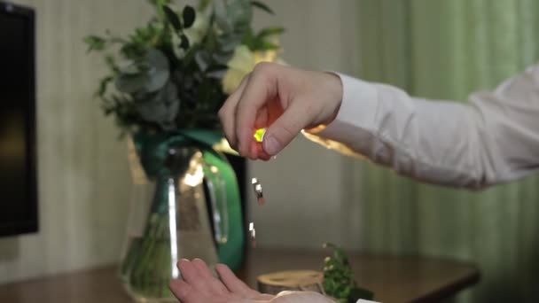 흰 셔츠 를 입은 그 룸 은 손에 결혼반지를 떨어뜨린다. 사람이 반지를 만진다 — 비디오