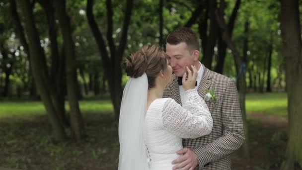 新婚旅行だよ。花嫁歩くと白人新郎,抱擁,公園で抱擁.結婚式のカップル — ストック動画