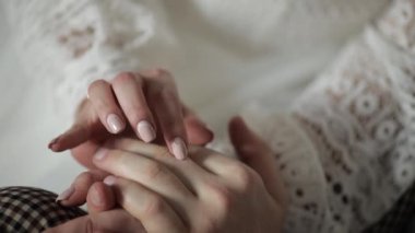 Yeni evlilerin elleri. Gelin ve damat birbirine dokunur. Birbirine aşık mutlu bir çift.