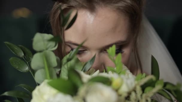 Schöne, schöne Braut im Brautschleier zu Hause. Brautstrauß in Händen von Bräutigam in Gesichtsnähe — Stockvideo