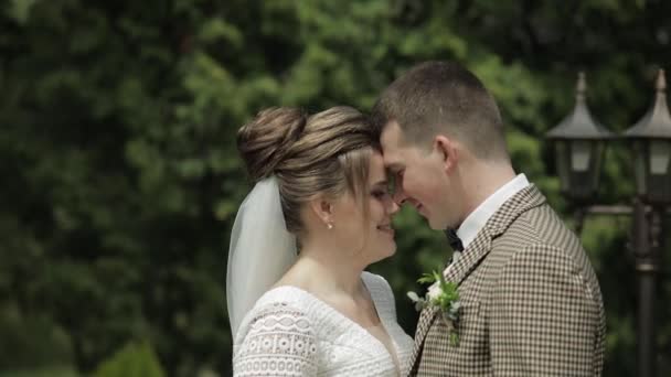 Sposi novelli. Sposo caucasico con sposa che cammina nel parco. Matrimonio. Uomo e donna innamorati — Video Stock