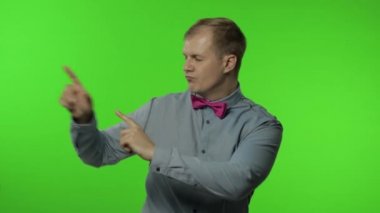 Yakışıklı adam dans ediyor, kaygısız gülümsüyor, trendler, başarı jestleri, kutluyor. Krom anahtar