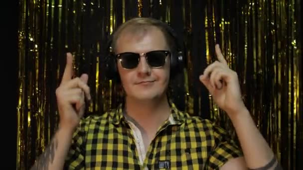 Portrait of caucasian man dancing on black background. Gold shining foil strips. Party, music, disco — Stock Video