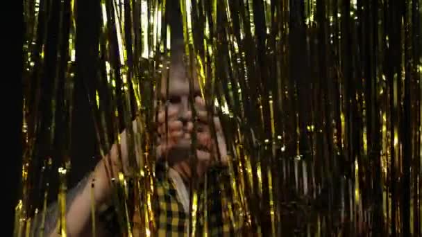 Retrato de homem caucasiano posando sobre fundo preto. Tira de papel alumínio dourado brilhante. Festa, música, discoteca — Vídeo de Stock