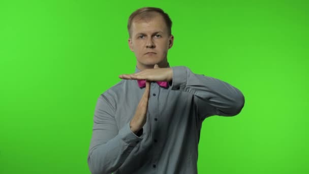 L'homme montre le panneau de sortie du temps. C'est limite, assez de geste. Portrait de gars sur fond chromatique — Video