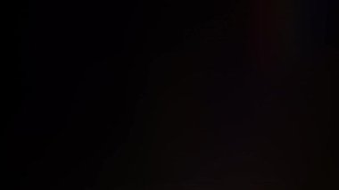 Işık sızıntısı 4K görüntüsü. Lens parlaklığı bokeh örtüleri, yanan alev arka planı. Flaş ışınları etkisi