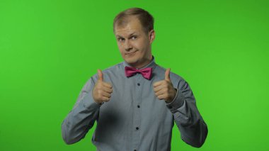 Adam olumlu bakıyor, iyimser bir şekilde gülümsüyor, tamam onaylama işareti.