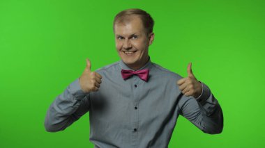 Adam olumlu bakıyor, iyimser bir şekilde gülümsüyor, tamam onaylama işareti.