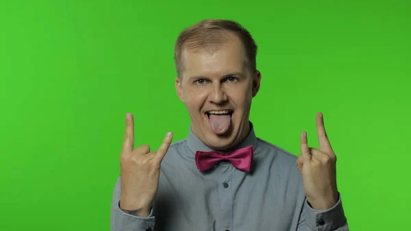 Hombre demostrando lengua, rock and roll gesto de la mano, signo punk, emocionado por la victoria, éxito loco — Foto de Stock