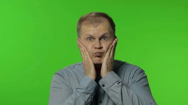 Comical man making silly face with inflates the cheeks, idiotic expression, grimace, fooling around — Stock Photo, Image