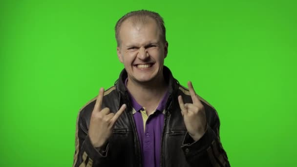 Rocker man toont rock 'n roll teken, duivel hoorns gebaar, op zoek met gekke uitdrukking — Stockvideo