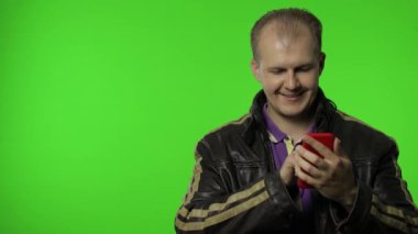 Rockçı adam reklam alanını gösteriyor. Akıllı telefon kullanmak, mesajın için duvara işaret etmek, logo