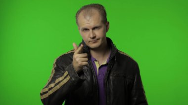 Sen delisin, aklın yerinde değil. Sinirli adam kamerayı işaret ediyor. Krom anahtarlı adamın portresi