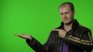 Reklam alanı gösteren bir adam. Şok olmuş görünüyorsun, promosyon metnin için ellerinle işaret ediyorsun, logo