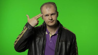 Adam silahı kafasına doğrultuyor, intihar jesti gösteriyor, kendini tabancayla vuruyor.