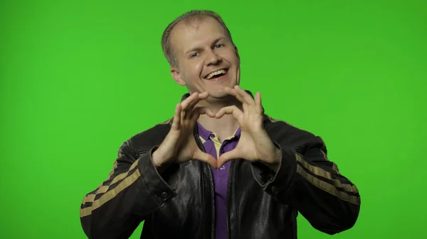 Brutaler Rocker zieht Herz-Geste aus Jacke und demonstriert romantische Gefühle — Stockfoto