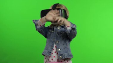 Çocuk kız oyun oynamak için kulaklık kullanıyor. Sanal gerçeklik 3D 360 videosunu izliyorum. Krom anahtar