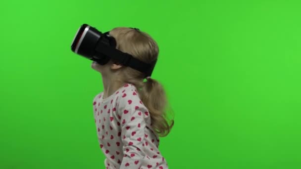 Девочка в шлеме гарнитуры играет в игру. Смотреть видео виртуальной реальности 3d 360. Ключ хрома — стоковое видео