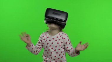 Çocuk kız simülasyon oyunu oynamak için VR uygulama kaskı kullanıyor. Sanal gerçeklik 3D video izliyor