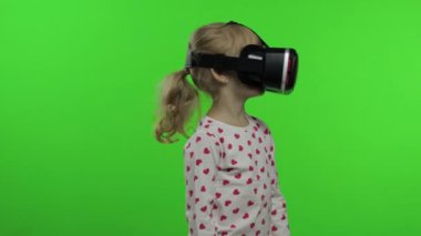 Çocuk kız oyun oynamak için kulaklık kullanıyor. Sanal gerçeklik 3D 360 videosunu izliyorum. Krom anahtar