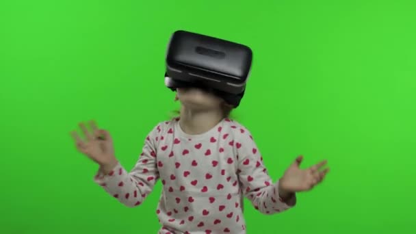 Niña usando casco de aplicación VR para jugar juego de simulación. Viendo la realidad virtual 3d video — Vídeos de Stock