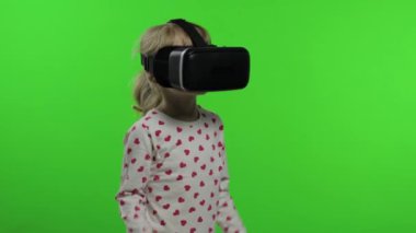 Çocuk kız oyun oynamak için kulaklık kullanıyor. Sanal gerçeklik 3D 360 videosunu izliyorum. Krom anahtar