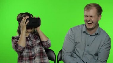 Erkek ve kadın oyun oynamak için kulaklık kullanıyor. Sanal gerçeklik 3D video izliyor. Krom anahtar