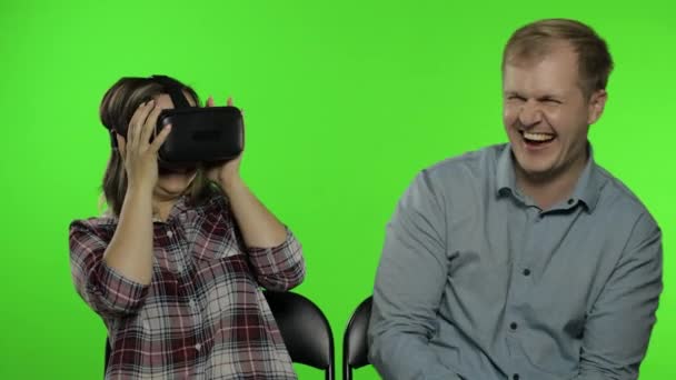 Άντρας και γυναίκα που χρησιμοποιούν κράνος VR για να παίξουν το παιχνίδι. Βλέποντας 3D βίντεο εικονικής πραγματικότητας. Κλειδί χρωμίου — Αρχείο Βίντεο