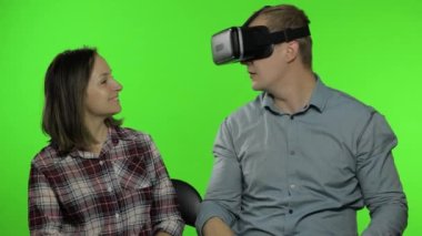 Erkek ve kadın oyun oynamak için kulaklık kullanıyor. Sanal gerçeklik 3D video izliyor. Krom anahtar