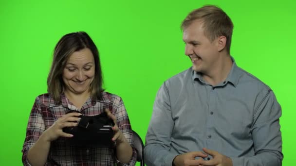 Mężczyzna i kobieta używający kasku VR do gry. Oglądanie wirtualnej rzeczywistości wideo 3D. Klucz chromowy — Wideo stockowe