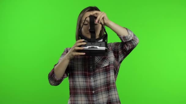 Ung kvinna använder VR headset hjälm för att spela spel. Titta på virtuell verklighet 3D 360-video. Kromnyckel — Stockvideo
