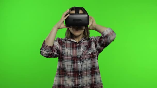 Молода дівчина використовує шолом додатків VR, щоб грати в симуляційну гру. Жінка дивиться віртуальну реальність 3d відео — стокове відео