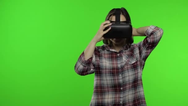 Młoda kobieta używająca kasku VR do gry, pokazująca poboczny obszar reklamowy. Klucz chromowy — Wideo stockowe