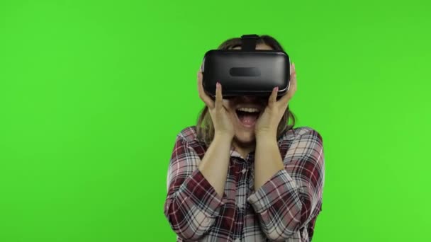 Dziewczyna korzystająca z kasku aplikacji VR do gry w przerażającą grę symulacyjną. Kobieta ogląda wirtualną rzeczywistość wideo 3D — Wideo stockowe