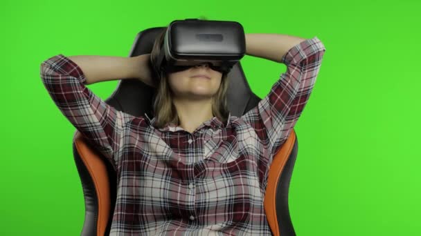 Νεαρή γυναίκα που χρησιμοποιεί κράνος VR για να παίξει το παιχνίδι. Παρατηρώντας εικονική πραγματικότητα 3d 360 βίντεο. Κλειδί χρωμίου — Αρχείο Βίντεο