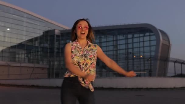 Mutlu kadın turist diş ipiyle dans ediyor, neşeyle dans ediyor, başarıyı kutluyor, müzikten hoşlanıyor. Gün batımı — Stok video