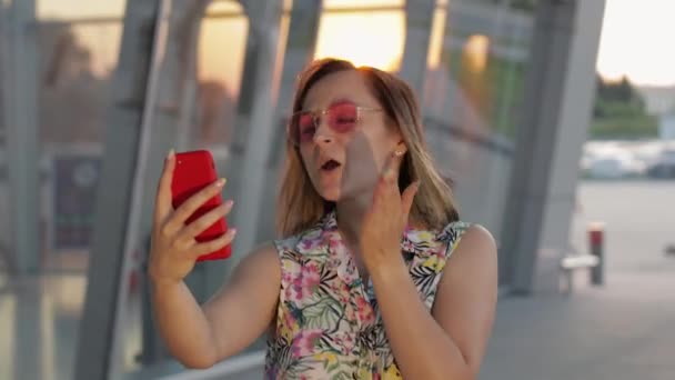 Chica turista con gafas de sol de moda utiliza el teléfono. Usando el smartphone para llamar, habla. Viaje, turismo — Vídeos de Stock