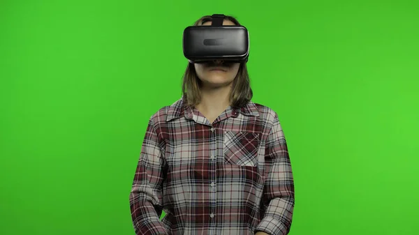 Mujer joven que usa casco de auriculares VR para jugar. Viendo la realidad virtual 3d 360 video. Clave de croma — Foto de Stock