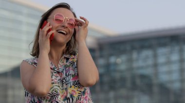 Moda güneş gözlüklü kız cep telefonundan arama yapıyor. Aramak için akıllı telefonu kullan, konuş