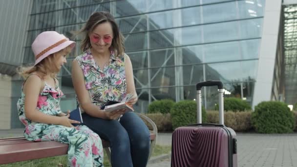 어머니와 딸이 공항 근처에 있어요. 여성은 여권과 티켓을 손에 쥐고 있다. 자녀 휴가와 어머니 휴가 — 비디오