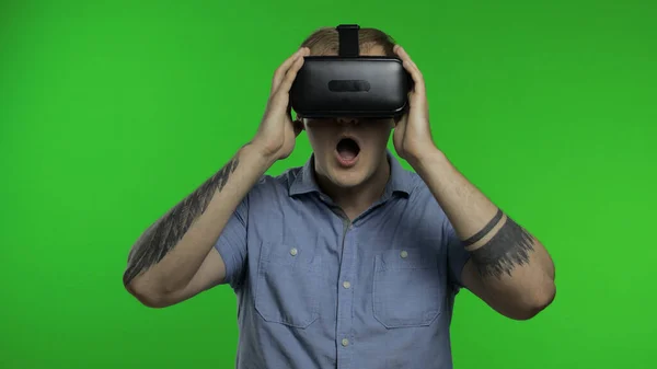 Man using VR app helmet to play simulation game, drawing. Guy watching virtual reality 3d video