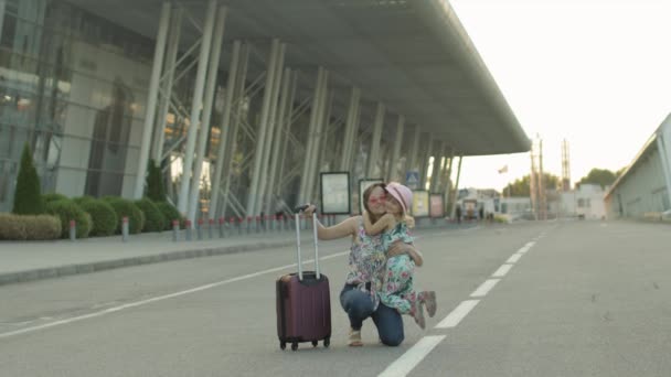 Anne ve kızı havaalanından yürüyerek geliyor. Çanta taşıyan kadın. Tatilden sonra çocuk ve anne — Stok video