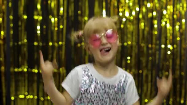 Een kind dat met zijn handen zwaait. Meisje 4-5 jaar oud poseren op de achtergrond met folie gordijn — Stockvideo