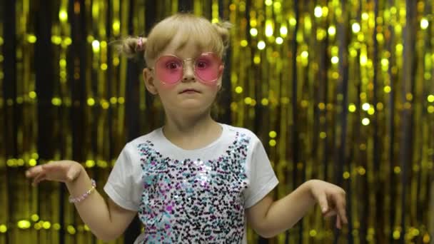 Danse d'enfant, spectacle stupéfiant, plaisanterie, sourire. Fille posant sur le fond avec rideau de papier d'aluminium — Video