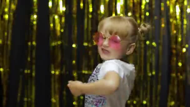 Child kid dancing, celebrating victory, fooling around. Girl posing on background with foil curtain — Stock Video